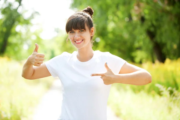 Mujer con camiseta blanca mostrando un pulgar hacia arriba — Foto de Stock