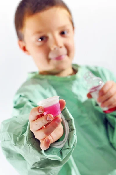 Pequeno médico menino dando xarope — Fotografia de Stock