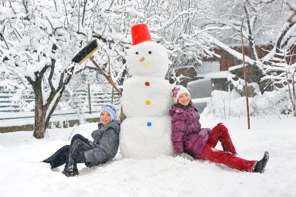 Snögubbe och barn — Stockfoto