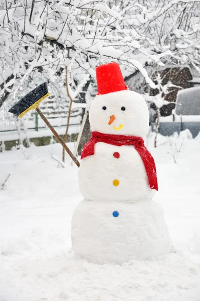 Snögubbe på snöig trädgård — Stockfoto