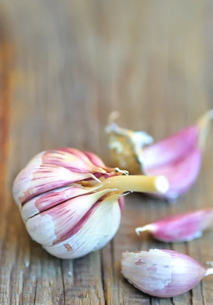 Giovani garlics su sfondo di legno — Foto Stock