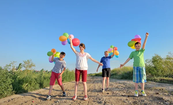Šťastné děti s barevnými balónky — Stock fotografie