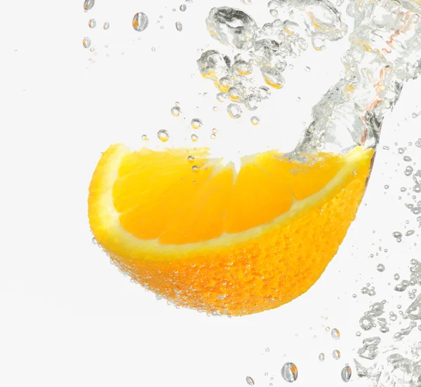 Лимонный ломтик падает в воду — стоковое фото