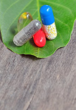 Vitaminler, tabletler ve yaprak yeşil hapları