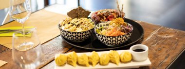 Modern bir füzyon restoranının seti üzerinde bir kase dürtme veya marine edilmiş çiğ balık ve ravioli ile yatay pankart veya başlık - Doğu füzyon yiyeceği ve uluslararası mutfak kavramı