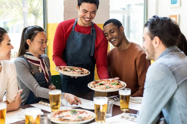 Fiducioso Cameriere Che Serve Deliziose Pizze Margherita Agli Amici Multiculturali — Foto Stock