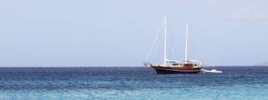 Horizontal banner or header with luxury sailing ship moored in turquoise water sea of wild Sardinia Island - Retro sailing yacht -Travel and luxury lifestyle concept - Wanderlust