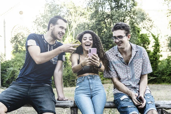 在大学花园使用智能手机的年轻多种族朋友 在公园与朋友分享视频通话的笑女 与总是相连接的朋友的技术概念 — 图库照片