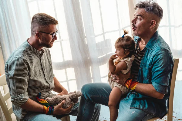 Evlatlık kızı olan erkek eşcinsel çift - kızlarıyla oynayan iki yakışıklı baba - Lgbtq + ailesi - çeşitlilik kavramı ve LGBTQ aile ilişkisi