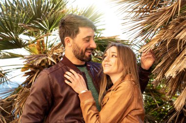 Romantik çift gün batımında birbirlerine bakıyor - sevgili ve sevgili egzotik doğada bir randevuda.