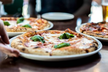 Margherita Napoli usulü mozarella soslu, domates soslu ve fesleğenli pizzayı yakından izleyin.