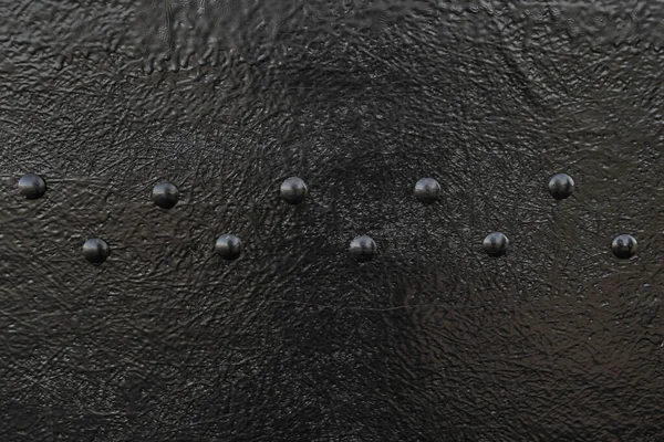 Large rivets on the black surface. Rivets on black metal