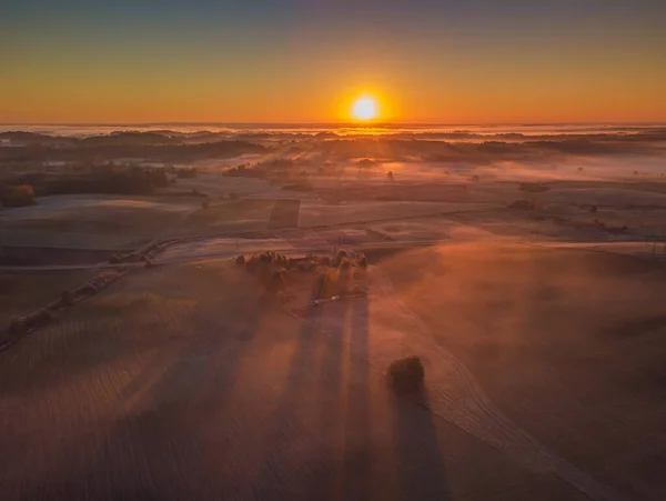 Amazing Sunrise Light Above Misty Landscape. Scénický pohled na mlhavé ráno v lesích Mlžného lesa. Letní příroda východní Evropy. Západ slunce Dramatický sluneční paprsek. — Stock fotografie