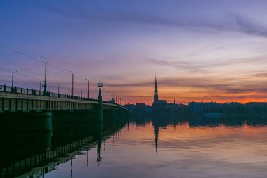 Yaşlı Riga 'nın üzerine gün doğumu Daugava' nın aynasına yansıdı.