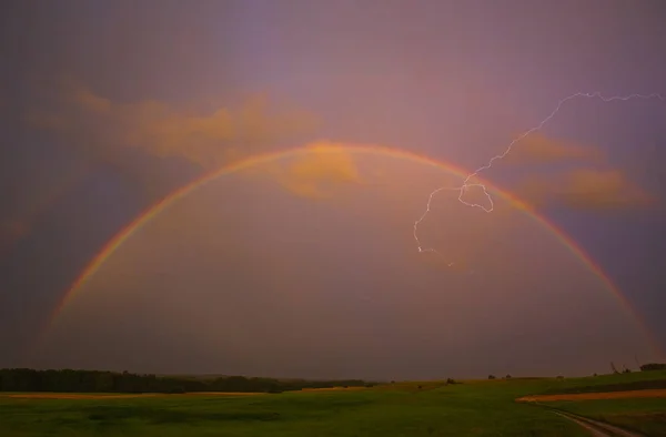 Lightning with with beautiful rainbow, fresh rain in the summer field landscape — Stock Photo, Image