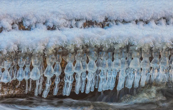 Icicles over the water in the river. Natural landscape. Winter. Background image. — Fotografia de Stock