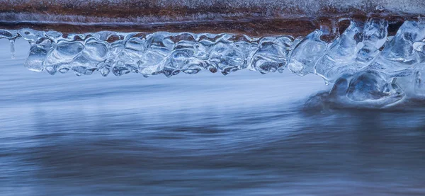 Icicles at winter, cold weather with icicles over river stream — Zdjęcie stockowe