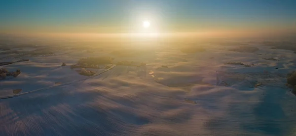 Vinter antenn panorama med vågiga ängar täckta av snö, tidig morgon ljus — Stockfoto