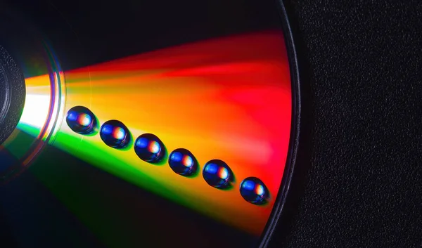 古いコンパクトCDディスクに光沢のある虹色の水が落ちます,背景のためのデザイン — ストック写真