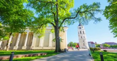 Vilnius 'taki şehir merkezinde, İlkbaharda Litvanya' daki Katedral Bazilikası 'nda, yeşil parkta yürüyen insanlar, 4k' lik bir zaman aralığı.