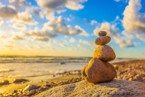 Stone tower on the beach with evening sunset light, zen stones, balance concept