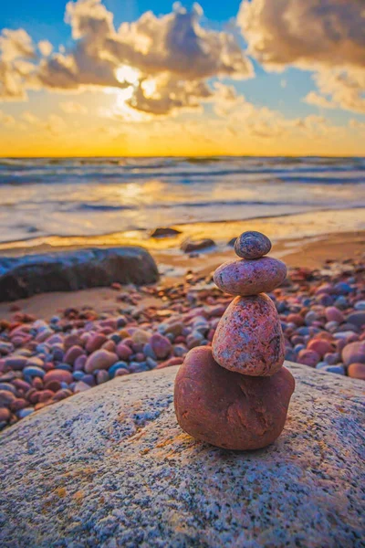 Stone tower on the beach with evening sunset light, zen stones, balance concept