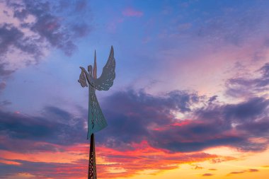 Holy Angel Sculpture against dramatic sky and clouds, background image of an angel