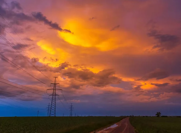 Electricity transmission power lines High voltage tower high-voltage lines. Transmission of electricity by means of supports through agricultural areas sunny day with landscape and dramatic clouds.