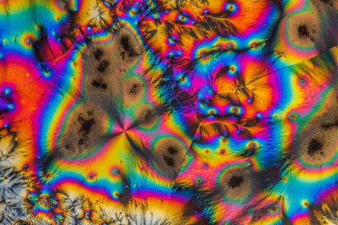 C vitamini kristallerinin uç makro fotoğrafları, polarize ışıkla aydınlatıldığında, 10x büyütme ile mikroskop altında soyut modern sanat modelleri oluşturur..