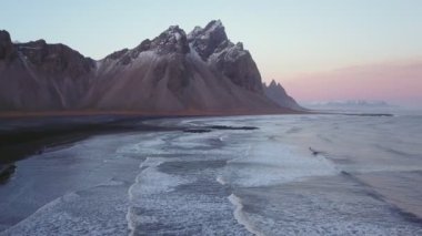 İzlanda, gün batımında Vestrahorn Dağı üzerinde uçan hava aracı.