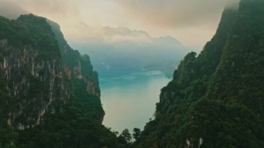 Hava aracı Tayland 'daki Khao Sok Parkı' ndaki dağ ve göl üzerinden geri çekiliyor.