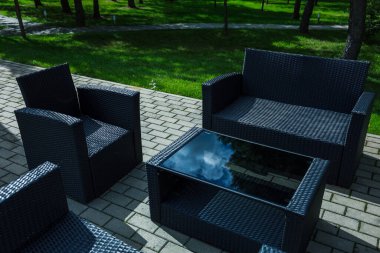 Oturma odası, kanepe, sehpa, kırmızı vazo ve çiçek.