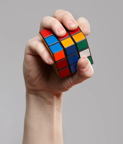 Hombre sosteniendo el cubo de Rubik en sus manos —  Fotos de Stock