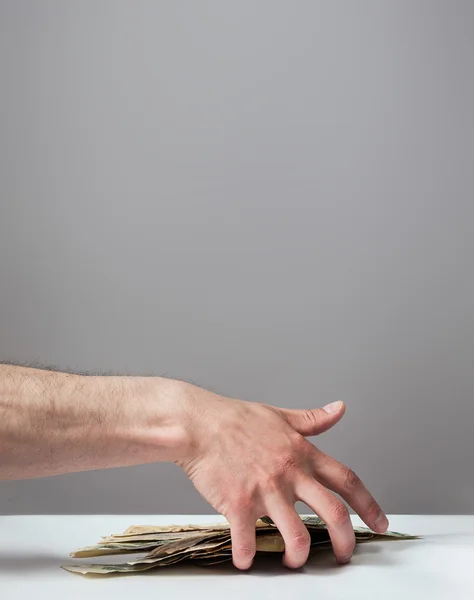 Many dollars falling on man's hand with money — Stock Photo, Image