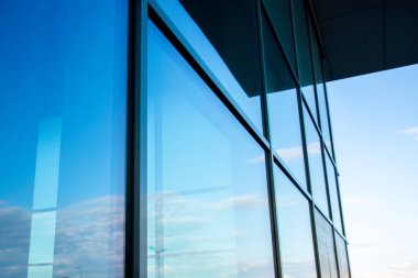 Cam pencereli bina mavi gökyüzünü yansıtır.