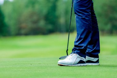 Golfçü sahada duruyor, golf sahasında golf oynuyor. Konsept vücudu güçlendiriyor, sağlıklı.