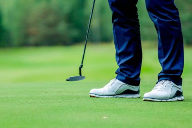 Golfçü sahada duruyor, golf sahasında golf oynuyor. Konsept vücudu güçlendiriyor, sağlıklı.