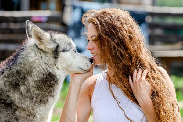 Belle femme rousse étreignant un husky — Photo