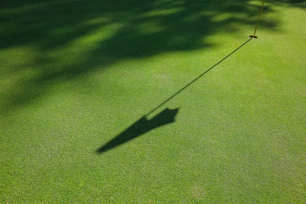 Bandeira sombra em um campo de golfe com grama verde — Fotografia de Stock