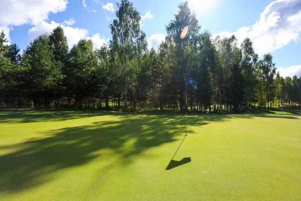 Ombra di bandiera su un campo da golf con erba verde — Foto Stock