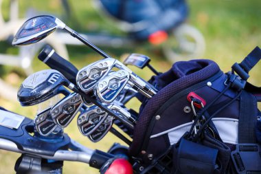 Minsk. Belarus - 16.10.2021 - Silver golf clubs in a bag on the field