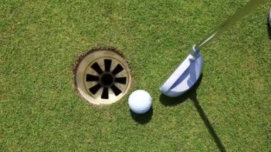 Putters and ball on a green golf course