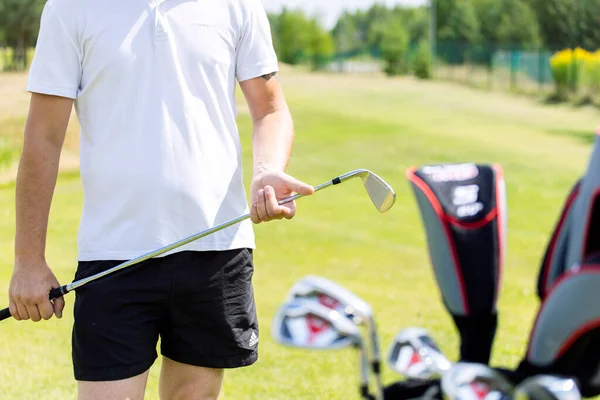 Primer plano de golfistas masculinos manos sosteniendo club de golf en hierba verde. —  Fotos de Stock