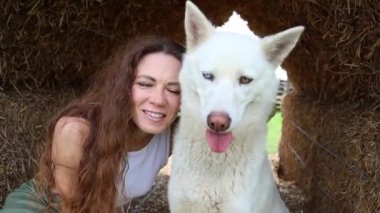 Güzel kızıl saçlı kadın, bir köpeğe sarılıyor.