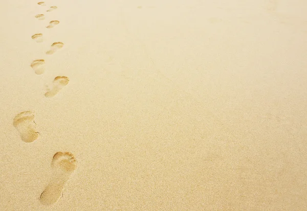 在砂背景中的脚印 — 图库照片