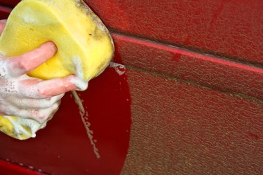 Cleaning automobile with soapy sponge clipart