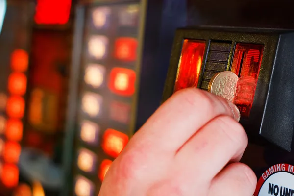 Inserindo libra esterlina moeda na máquina de jogos — Fotografia de Stock