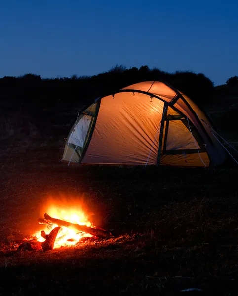 illuminated tent and campfire