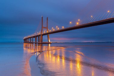 Lizbon Köprüsü 'nde gece lambaları. Vasco da Gama Köprüsü bir dönüm noktasıdır ve dünyanın en uzun köprülerinden biridir. Şehir manzarası. Portekiz inanılmaz bir turistik yerdir.