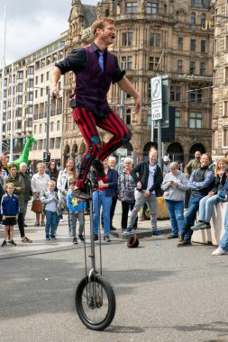 Edinburgh Festival Fringe 2022- 5 Aug-29 Aug, Edinburgh UK. events to mark its 75th anniversary. Performers  on the street. Actors of street theater and musicians in capitol of Scotland. The artist on a on one wheel bicycle.